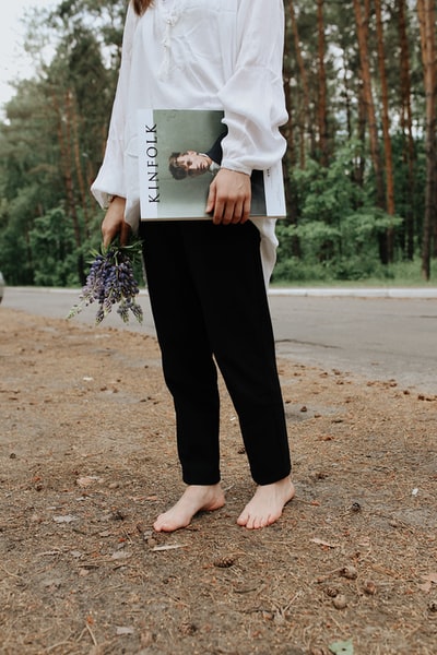 A woman holding a white hardcover book
